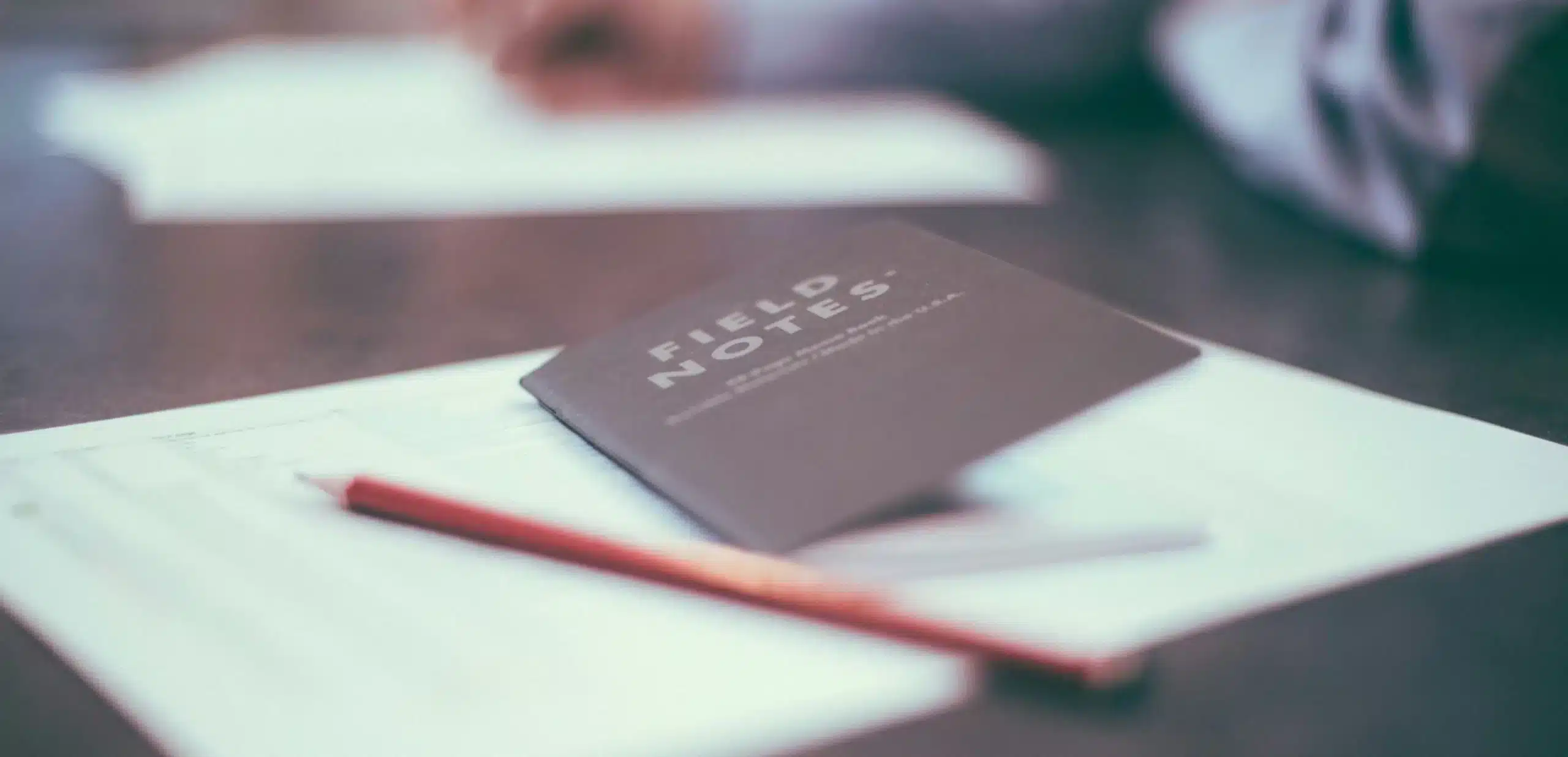 a pencil and a notebook with data to do a carbon footprint