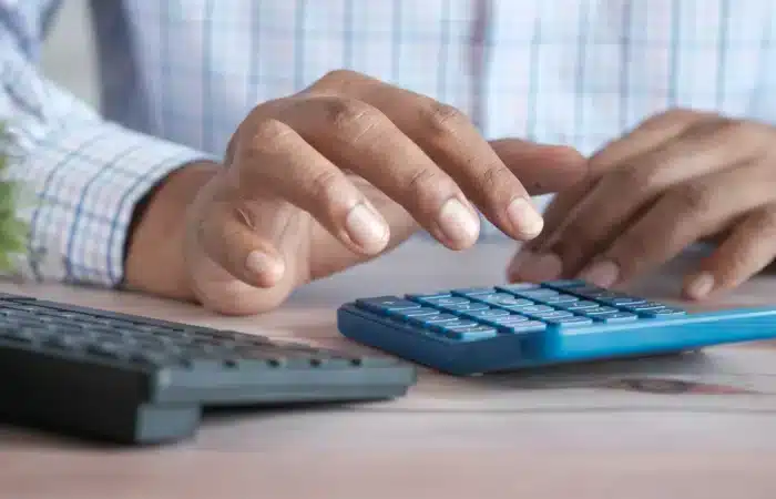 Quelqu'un avec une calculatrice qui consolide ses bilans exigés par la CSRD