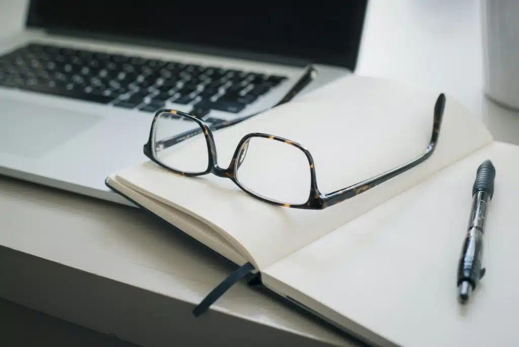 Black glasses on a notepad.