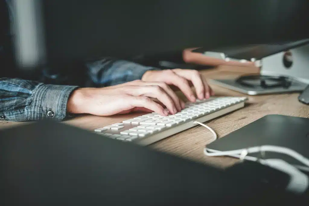 A man typing on his keyboard to create his Scope 3 emissions report